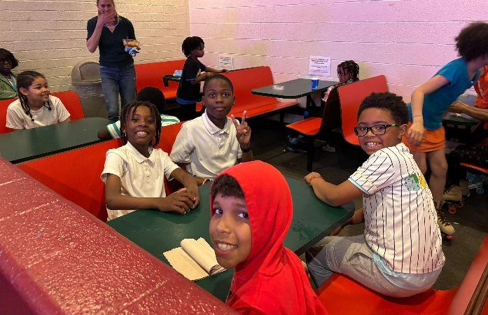  students sitting at table at skating rink